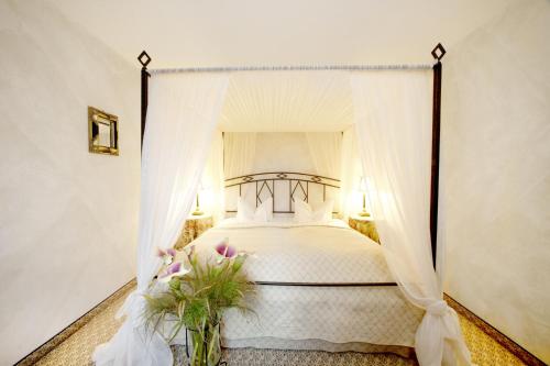 a bedroom with a white bed with a canopy at Romantik Hotel Jagdhaus Waldidyll in Hartenstein