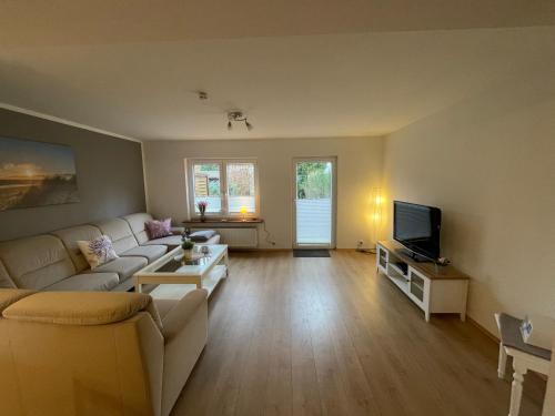 a living room with a couch and a tv at Ferienhaus Groß Grönau in Groß Grönau