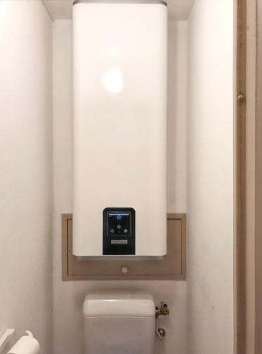 La salle de bains est pourvue de toilettes et d'une horloge murale. dans l'établissement Appartement convivial à Gassin 37 m² avec vue sur la mer, à Gassin