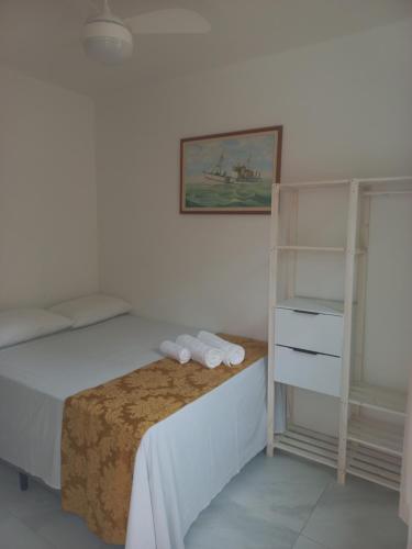 a bedroom with a bed with towels on it at Pousada Rota do Sol in Cabo Frio