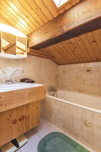 une salle de bain avec un lavabo et une baignoire dans l'établissement Chalet chaleureux à Champagny-en-Vanoise avec jacuzzi, à Champagny-en-Vanoise