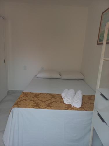 a bedroom with a bed with two towels on it at Pousada Rota do Sol in Cabo Frio
