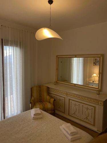 a bedroom with a mirror and a bed and a chair at Villa Perla del Sole in Baiardo