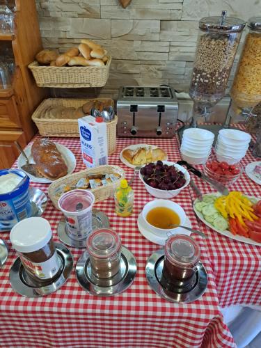 a table with a red and white checked table cloth with food at Penzion Havran in Ždiar