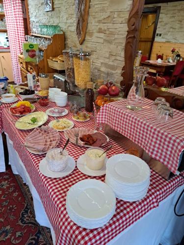 a table with plates of food on a red and white table cloth at Penzion Havran in Ždiar