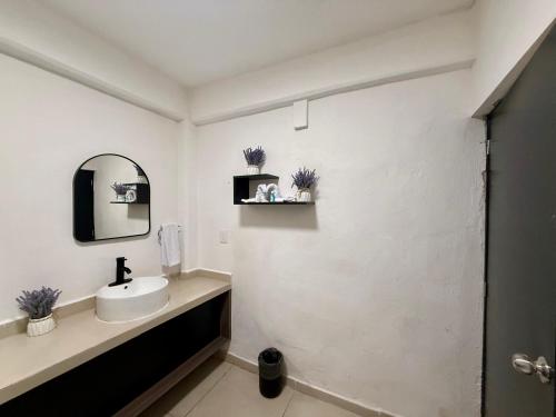 a white bathroom with a sink and a mirror at CASA TORTUGA 5Th Ave in Playa del Carmen