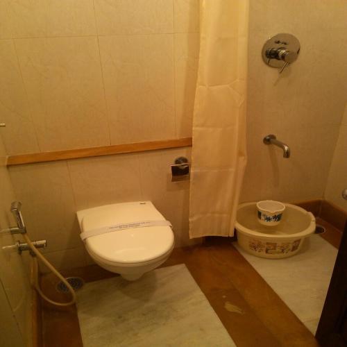 a small bathroom with a toilet and a shower at RKN Hotel in Puducherry