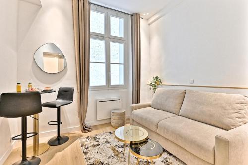 un salon avec un canapé et un miroir dans l'établissement Studio Chic in Paris- III, à Paris