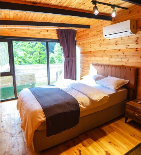 a bedroom with a bed in a wooden wall at Tina Bungalov in Sapanca