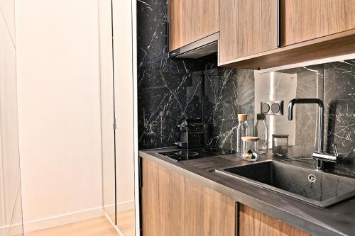 une cuisine avec un évier et un comptoir dans l'établissement Studio Chic in Paris- III, à Paris