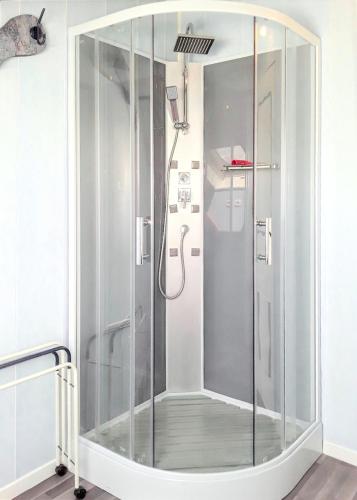 une douche avec une porte vitrée dans une salle de bain dans l'établissement Appartement accueillant à Selonnet de 80 m² avec piscine partagée, à Selonnet