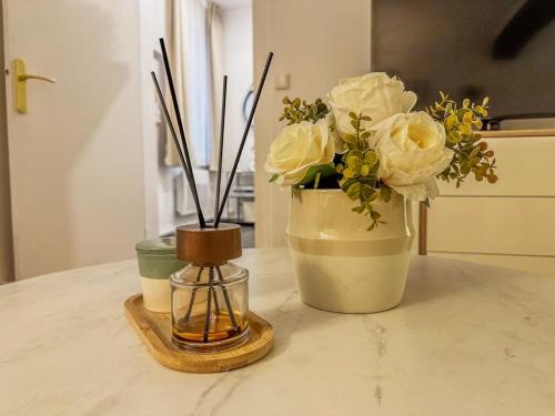Deux vases avec des fleurs et une bougie sur un comptoir dans l'établissement Le Studio Green - 2 people, à Chartres