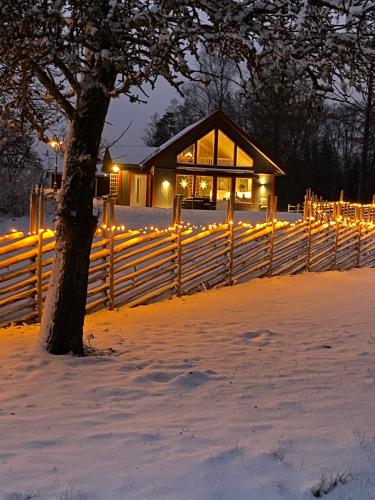 a house with lights in the snow at night at Joarsbo, Stuga 3, Klinten in Kalv