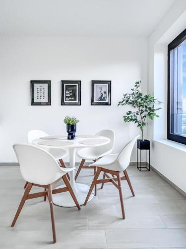 a white dining room with a white table and chairs at New Studio in Belval in Sanem
