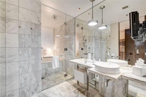 a white bathroom with a sink and a shower at Stunning Strip View Studio w BALCONY ACCESS 35308 in Las Vegas