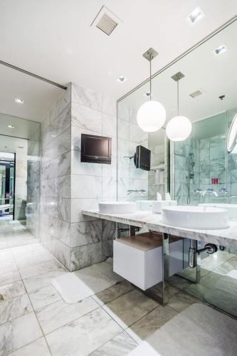 a bathroom with three sinks and a large mirror at Stunning Strip View Studio w BALCONY ACCESS 35308 in Las Vegas