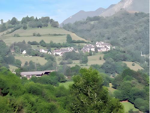 un village sur une colline avec des maisons et des arbres dans l'établissement Charmant Bungalow à Juncalas avec Terrasse et Vue Montagne, à Juncalas