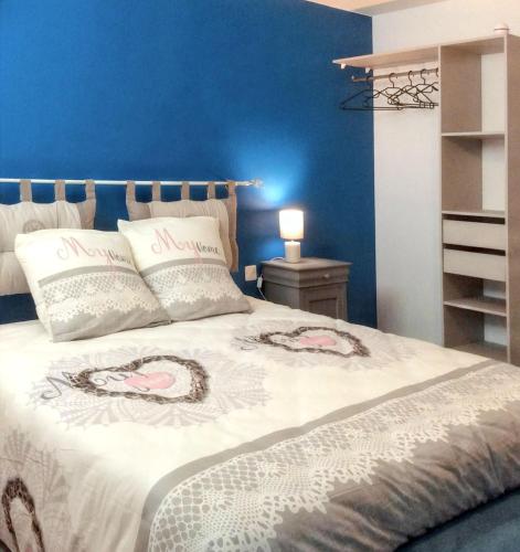 une chambre avec un lit avec un mur bleu dans l'établissement Maison charmante avec piscine à Loupiac, à Loupiac