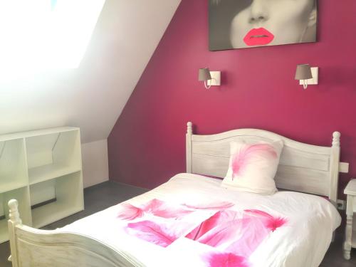 LoupiacにあるMaison charmante avec piscine à Loupiacのベッドルーム1室(ピンクの羽毛が付いた白いベッド1台付)