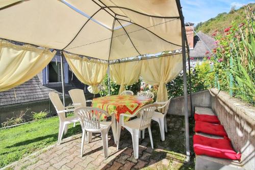 a patio with a table and chairs under an umbrella at Appartement charmant à Juncalas - 30 m² - Vue sur la montagne in Juncalas