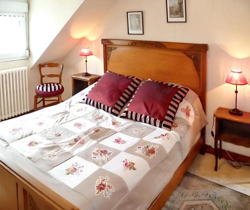 une chambre avec un grand lit avec des oreillers rouges dans l'établissement Maison confortable à Châteaulin avec jardin et terrasse., à Châteaulin