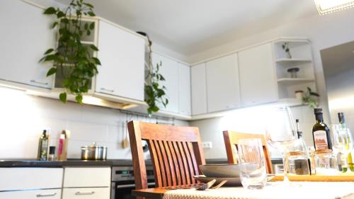 a kitchen with white cabinets and a table and chairs at Zentrale, gemütliche Dachgeschoss-Etage - 52qm - Altes Haus auf 2,5 Etagen exklusiv für Dich - mit 1 Schlafzimmer, Wohnzimmer und Rückzugsraum zum Verweilen - Küche, großes Bad, Netflix in Halle an der Saale