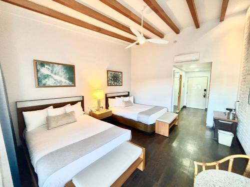 a hotel room with two beds and a ceiling at San Nicolas Hotel Casino in Ensenada