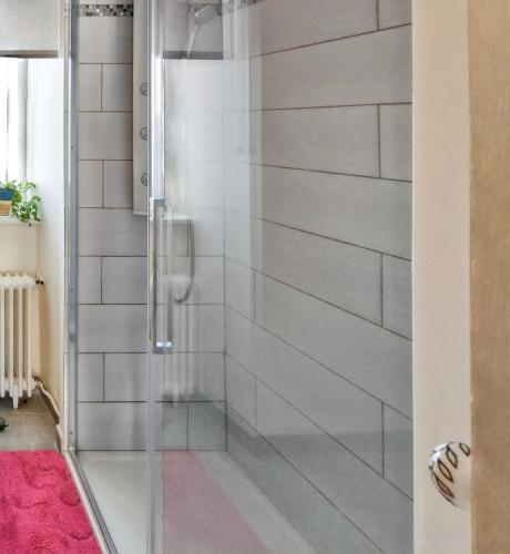une douche avec une porte vitrée dans une salle de bain dans l'établissement Maison charmante à La Porcherie, à La Porcherie