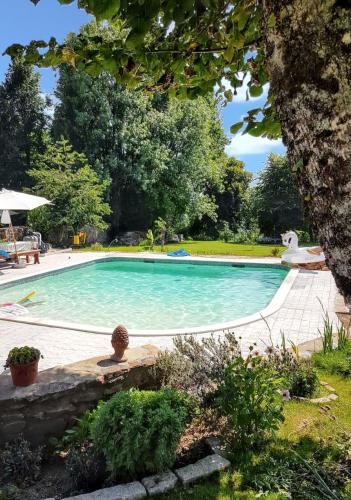 - une piscine dans une cour avec un arbre dans l'établissement Maison charmante à La Porcherie, à La Porcherie