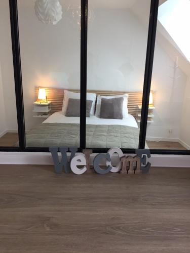 une chambre avec un lit et une grande fenêtre en verre dans l'établissement Appt au pied de la cathédrale avec parking gratuit, à Amiens