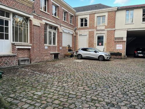 une voiture garée devant un bâtiment en briques dans l'établissement Appt au pied de la cathédrale avec parking gratuit, à Amiens