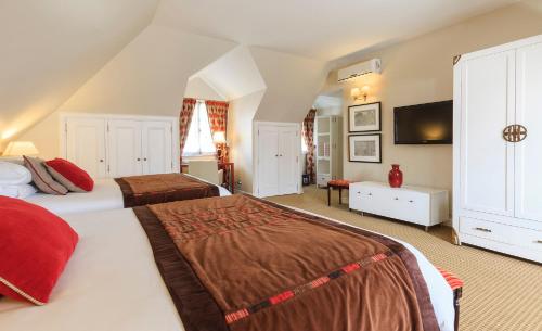 a bedroom with two beds and a flat screen tv at Hotel Boutique Le Reve in Santiago