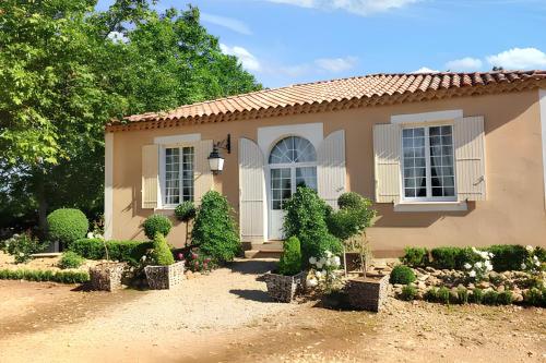a small house with bushes and flowers in front of it at Maison accueillante à Arles - Jardin, Parking privé in Arles