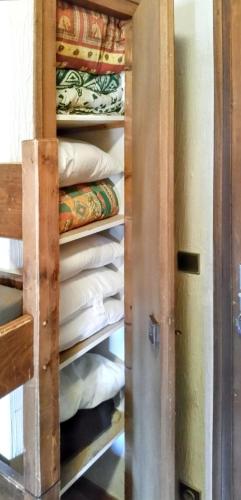 - un placard avec une pile de couvertures et d'oreillers dans l'établissement Appartement agréable à Saint-Gervais-les-Bains de 30 m² avec piscine, à Saint-Gervais-les-Bains