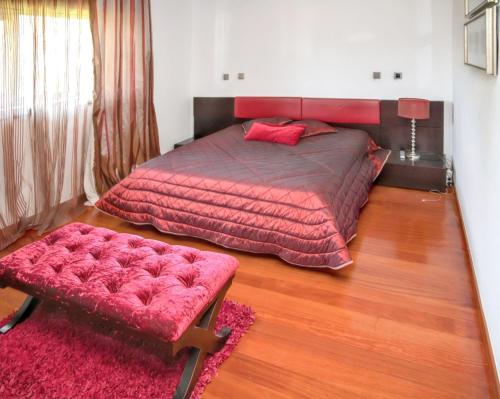 a bedroom with a large bed with a red comforter at Spacious villa in Santo Tirso with private pool 850 m² and jacuzzi in Santo Tirso