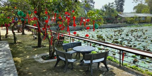 a table and chairs in front of a pond with ducks at Lux Home Phước Hải 2 in Hội Mỹ