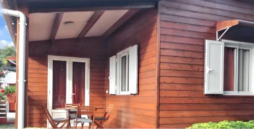 a wooden house with chairs and a table on it at Maison charmante à Saint Paul avec vue mer et montagne in Saint-Paul