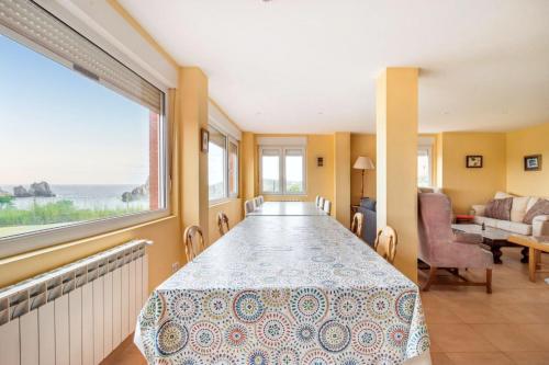 a dining room with a table and a view of the ocean at Spacious house with sea view in Liencres + jacuzzi in Liencres