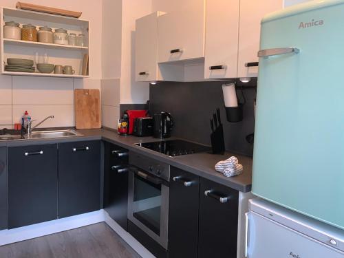 a kitchen with black cabinets and a stove top oven at City-Apartment mit Stil und Charme in bester Lage in Bielefeld