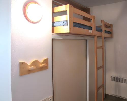 a small room with a bunk bed and a ladder at Charmant studio vue mer à Pornichet 30 m² avec terrasse in Pornichet