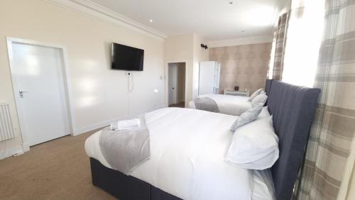a bedroom with two beds and a flat screen tv at Ye Olde Hotel in Leuchars