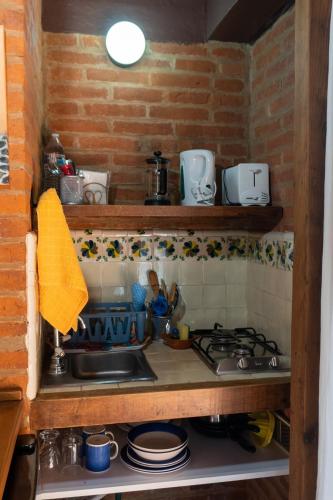 a kitchen counter with a sink and a stove at Cozy Nature Escape in Tepoztlán in Tepoztlán