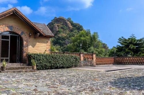 a house with a fence in front of a mountain at Cozy Nature Escape in Tepoztlán in Tepoztlán