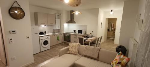 un salon avec un canapé et une cuisine dans l'établissement Le Portet avec parking privé, à Angers