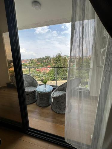 a balcony with two wicker chairs and a table at Cascadia Apartments Kigali in Kigali