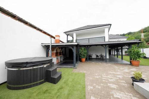 a house with a grill in the yard at Casa Dacia in Eşelniţa