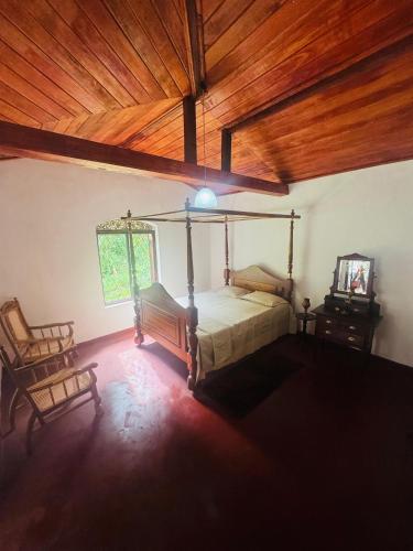 a bedroom with a bed and a wooden ceiling at Galagoda Mansion in Matale