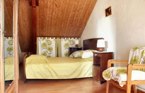 1 dormitorio con cama con sábanas amarillas y techo de madera en Charmante maison à Sarrazac avec piscine privée, en Sarrazac