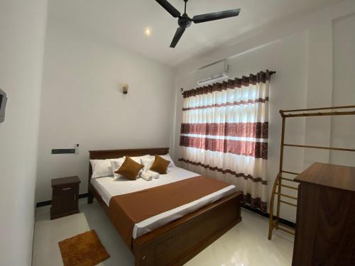 a bedroom with a bed and a ceiling fan at Coco Bay Villa in Galle