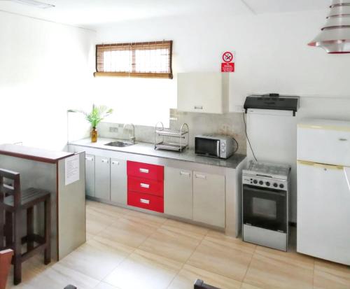 a kitchen with white cabinets and a stove top oven at Modern apartment in Pereybère with pool view, 50 m² in Pereybere